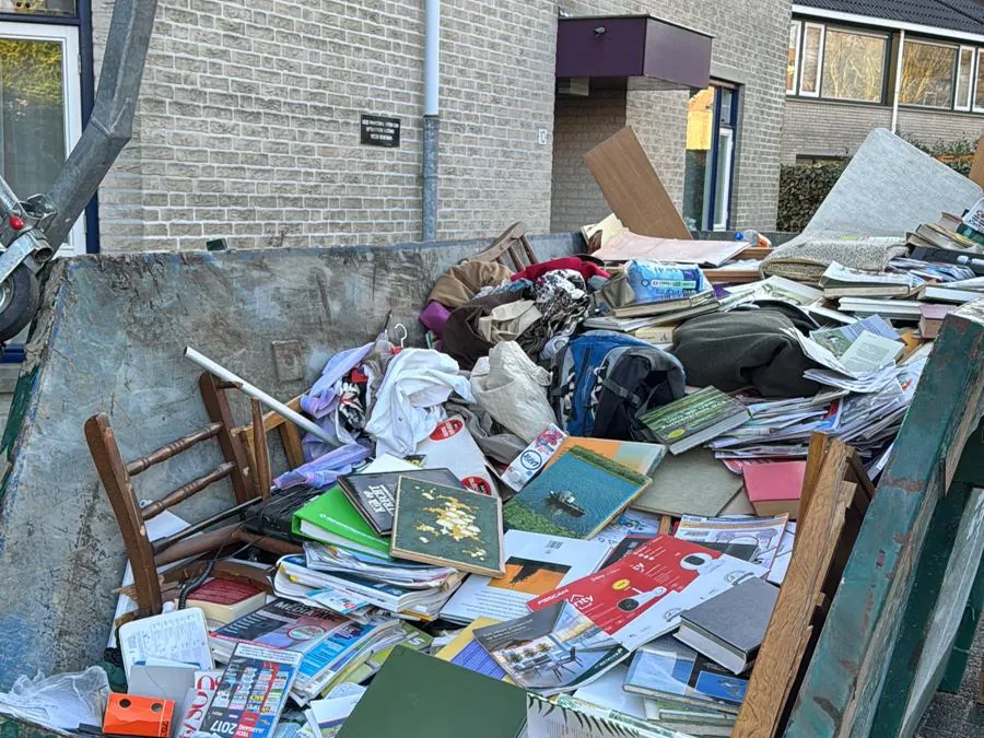 Container met afgevoerde inboedel bij de woning